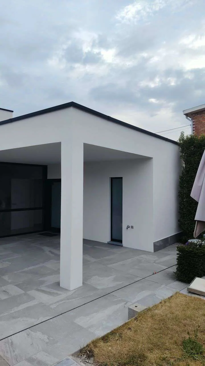 Witte crepi-afwerking aan een moderne woninguitbreiding