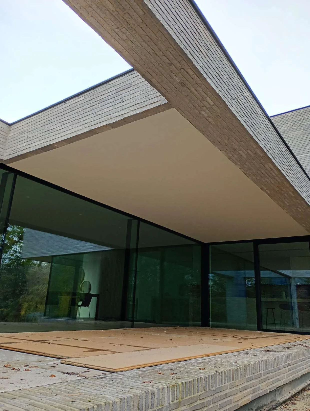 Architecturaal geveldetail met steenstrips en grote glaspartijen